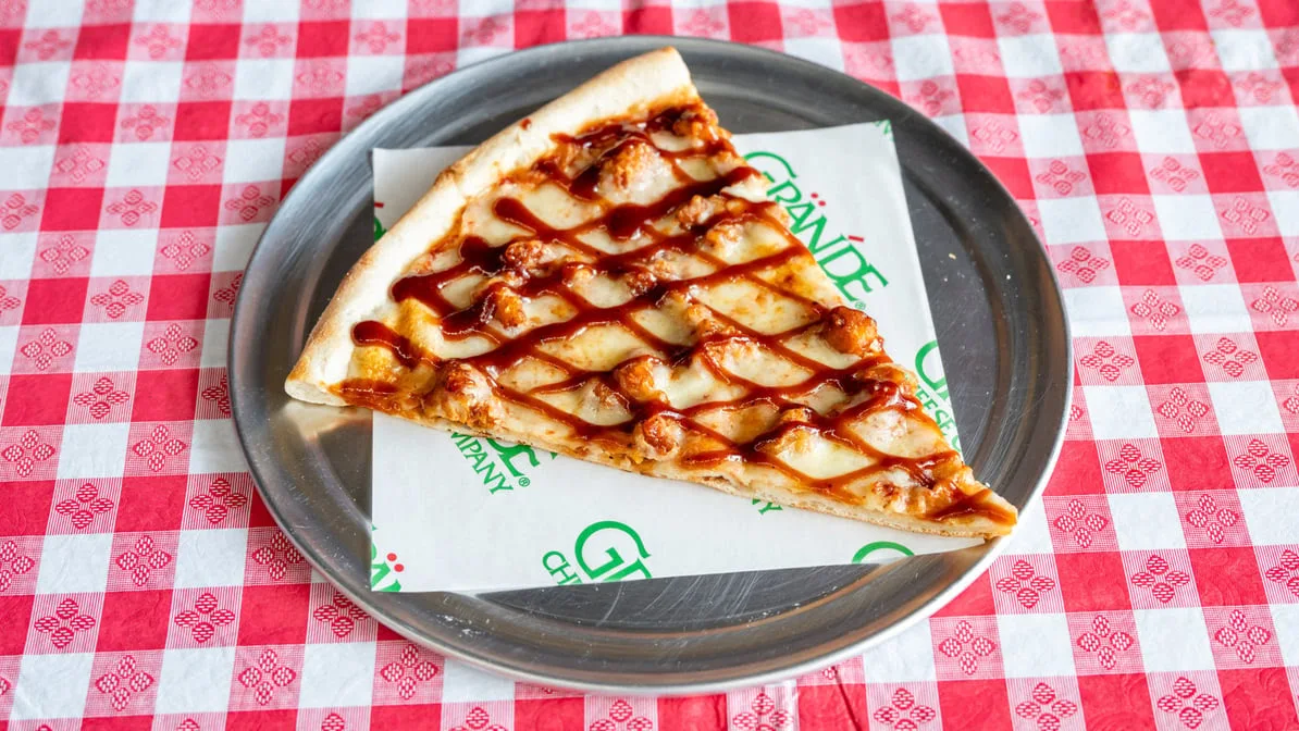 BBQ chicken pizza slice with sauce drizzle