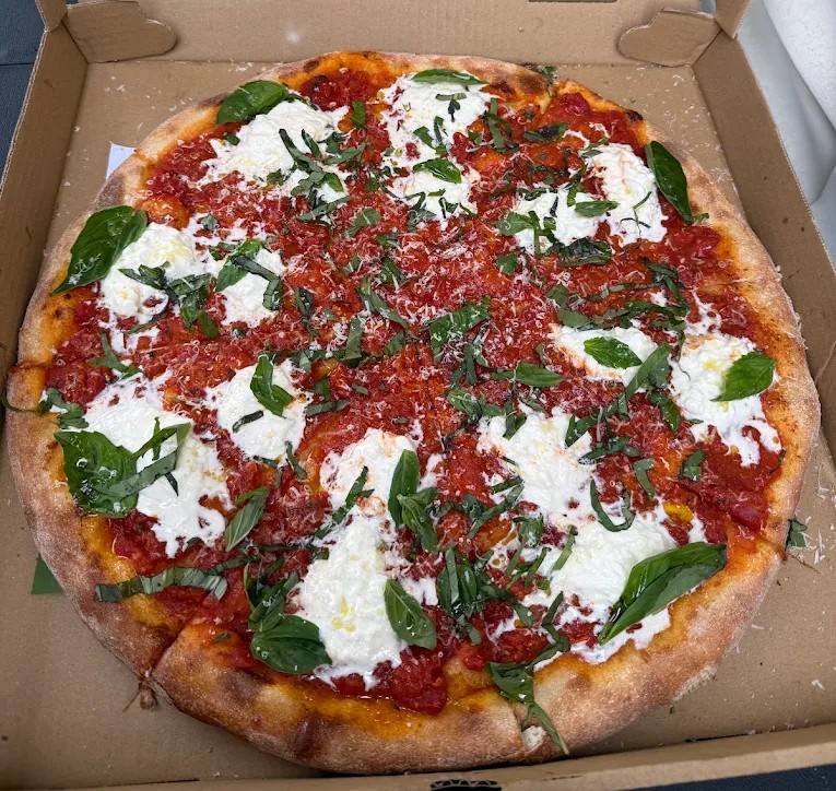Whole margherita pizza with fresh mozzarella and basil