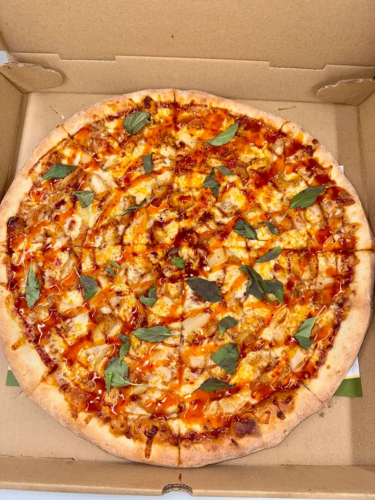Whole specialty pizza loaded with chicken, sauce drizzle and fresh basil from Quick Slice Pizza