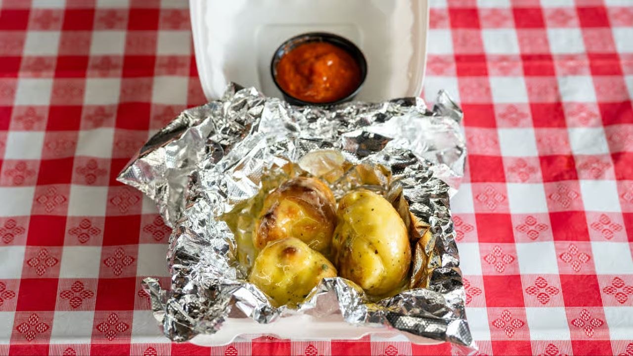 Golden baked garlic knots from Quick Slice Pizza, served with marinara dipping sauce