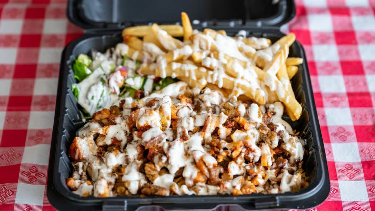 Chicken over rice platter with fries, salad and white sauce from Quick Slice Pizza