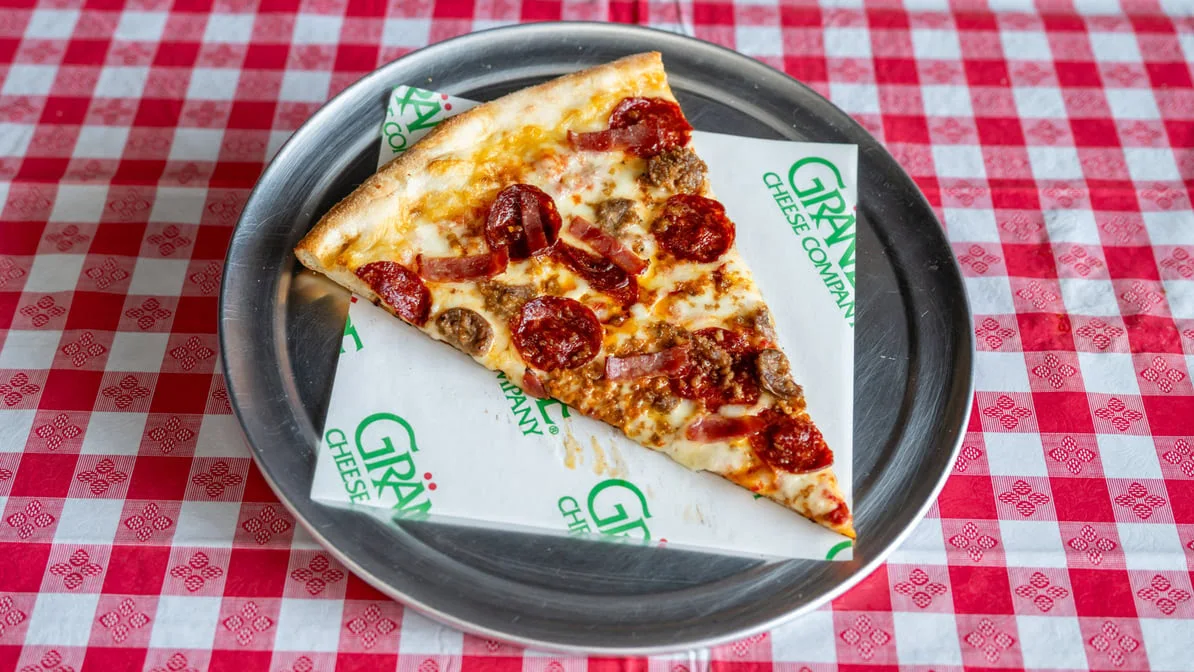 Slice of pizza on a plate from Quick Slice Pizza